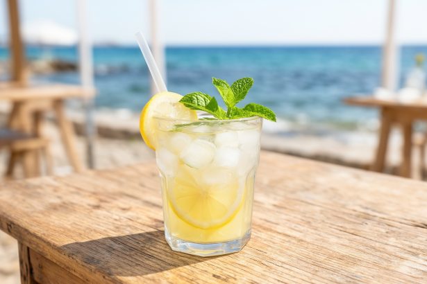 Szklanka domowej lemoniady z miętą i lodem na tle bułgarskiego wybrzeża.
