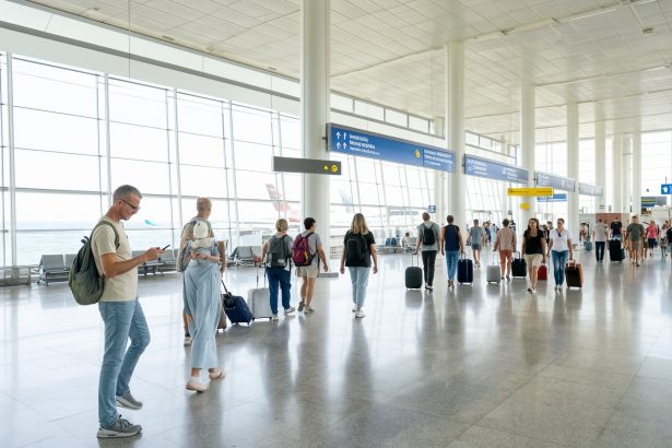 Podróżny sprawdzający telefon w hali przylotów na lotnisku w Burgas.